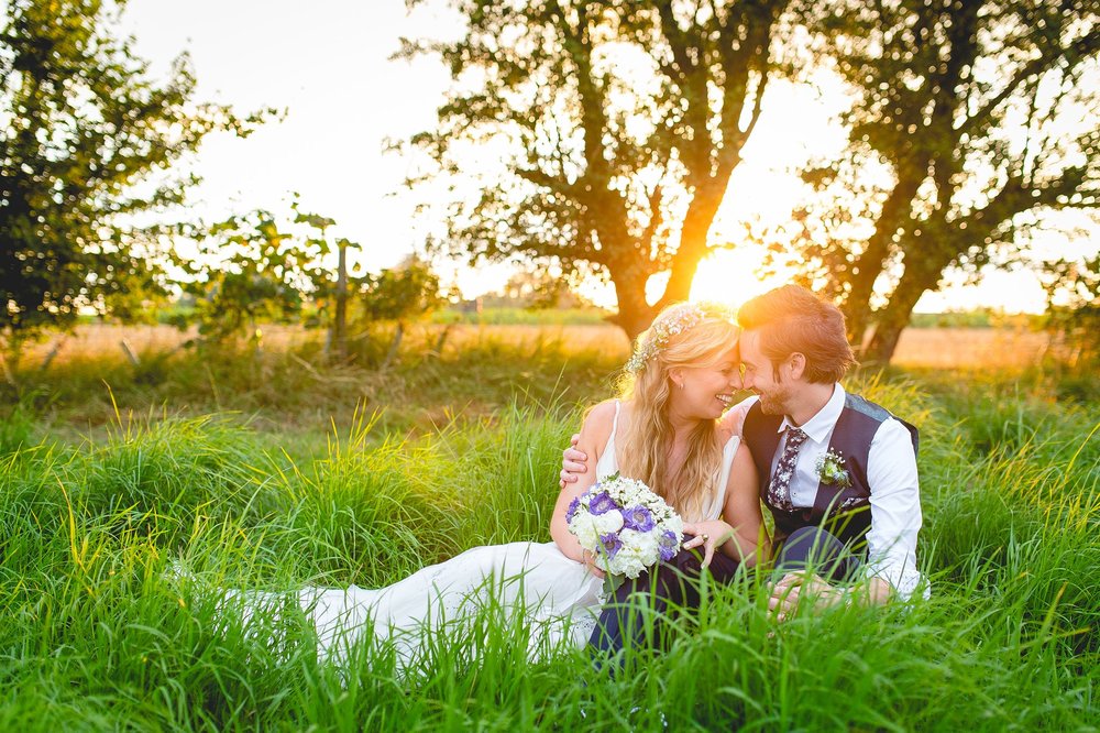 bride and groom sat in lancashire fields